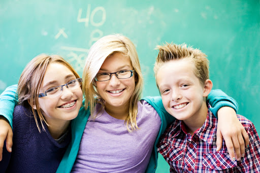 three children smiling with braces